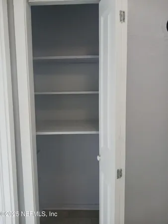 a view of walk in closet with empty racks