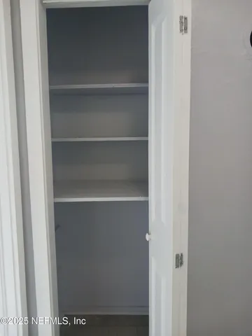 a view of walk in closet with empty racks