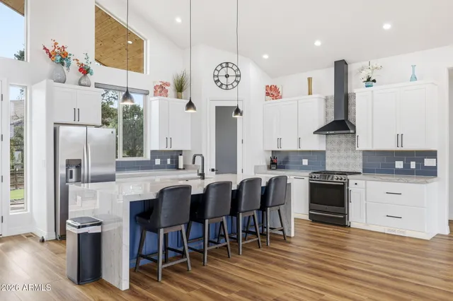 an open kitchen with wooden floor and large windows