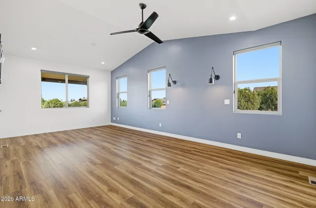 a view of a hallway with wooden floor and a ceiling fan