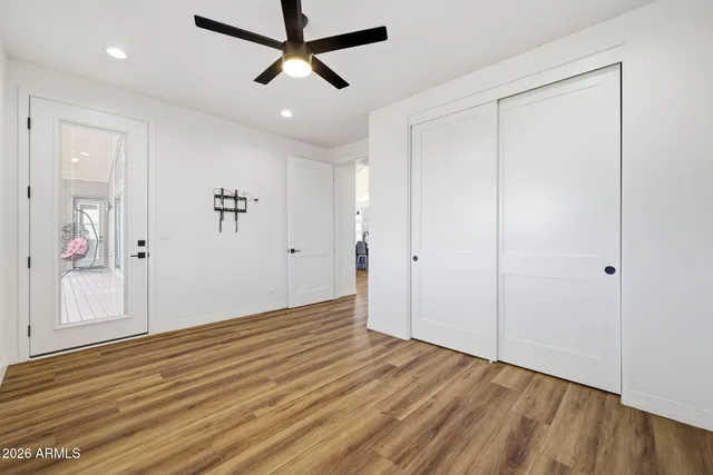 a view of a big room with windows and ceiling fan