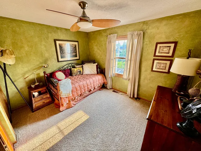 a bedroom with a bed and a painting on the wall