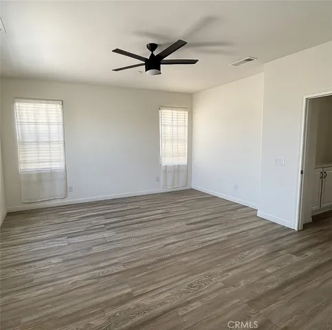 a view of empty room with wooden floor and window