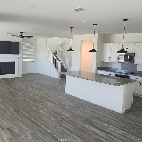 a kitchen with kitchen island a counter top space wooden floor and appliances