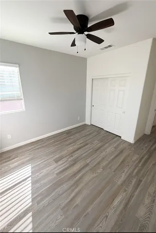 en empty room with wooden floor and ceiling fan