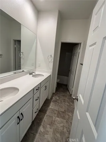 a spacious bathroom with double vanity and mirrors
