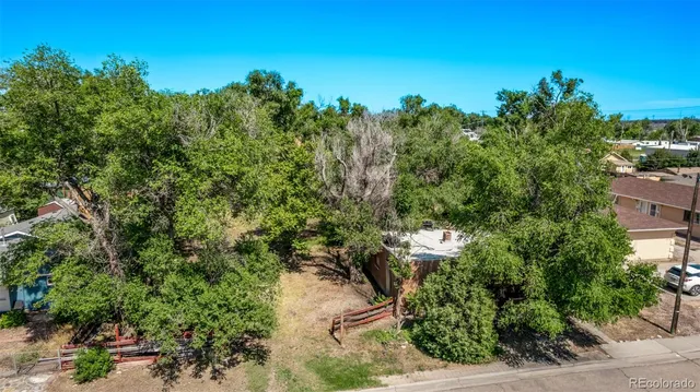 an aerial view of residential houses with outdoor space and trees
