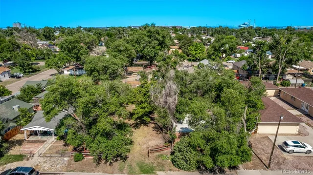 an aerial view of residential houses with outdoor space and trees