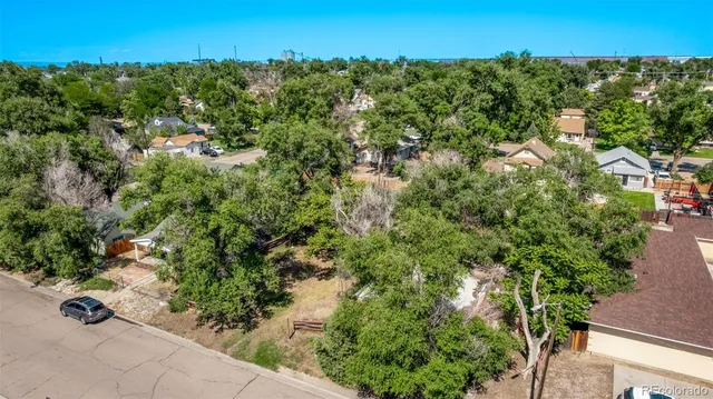 an aerial view of residential houses with outdoor space and trees