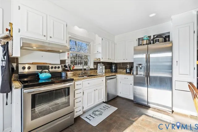 a kitchen with stainless steel appliances granite countertop a refrigerator sink and stove