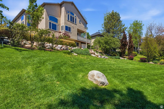 12317 Cypress Point Way Draper, UT 84020 - Photo 35 of 41 Stucco exterior featuring multiple arched and rectangular windows, a lower-level balcony, and varied landscaping