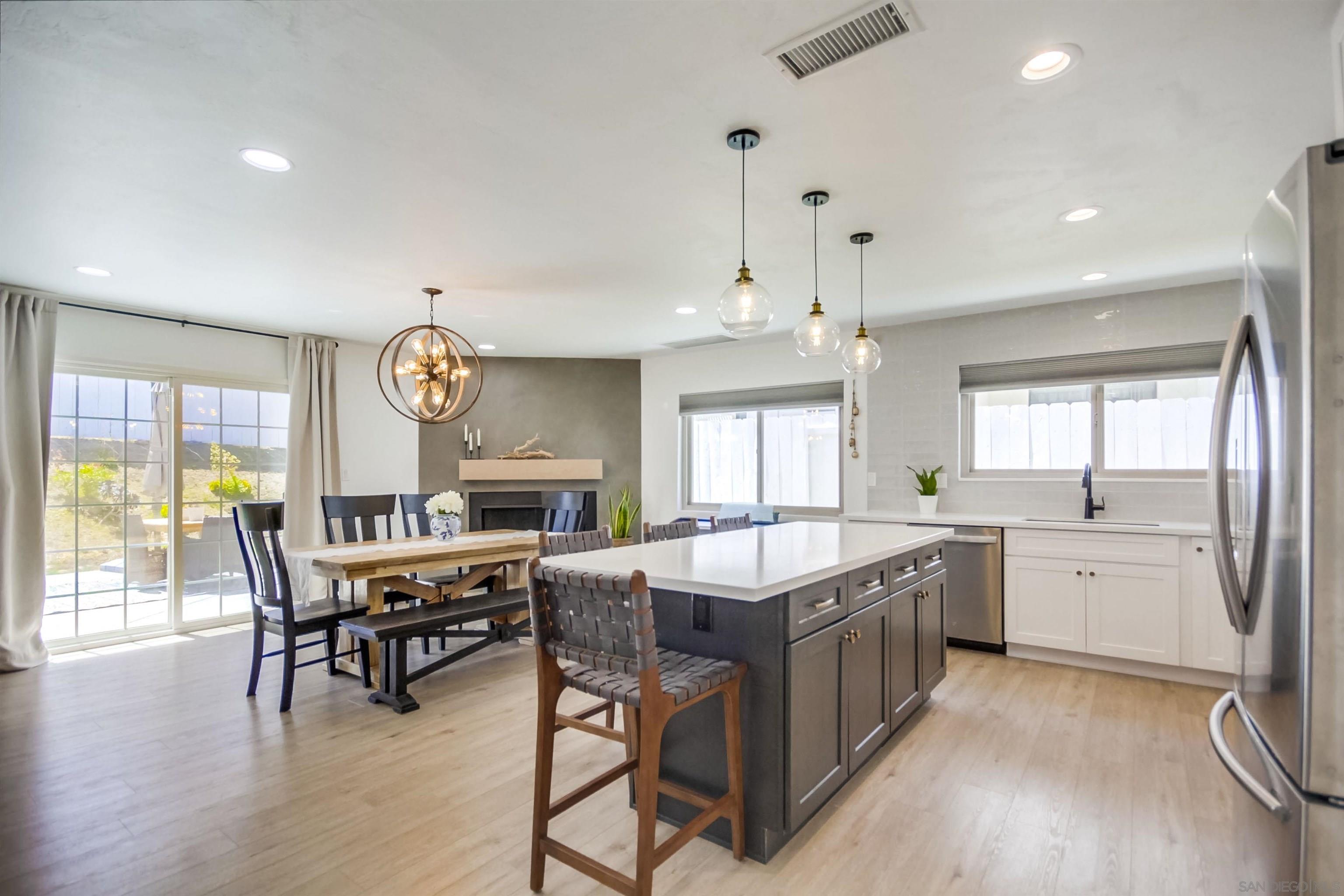 a kitchen with stainless steel appliances granite countertop dining table chairs and white cabinets