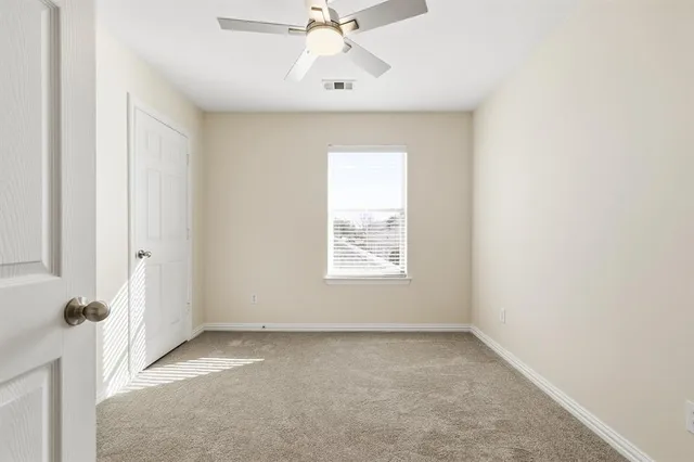 an empty room with a window and a fan