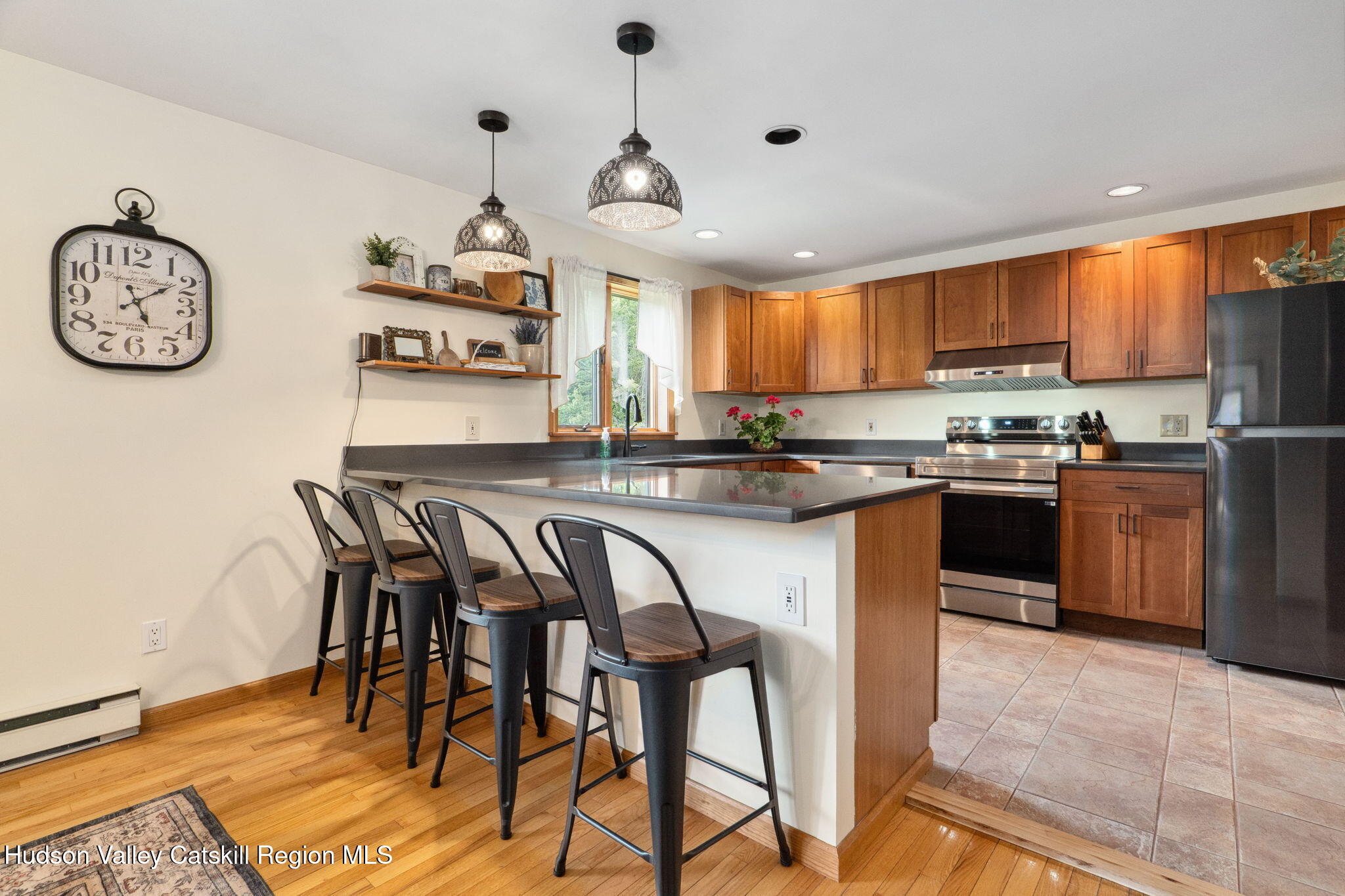 552 Bear Kill Road Gilboa, NY 12076 - Photo 20 of 63 a kitchen with stainless steel appliances granite countertop a table chairs a stove a refrigerator and cabinets