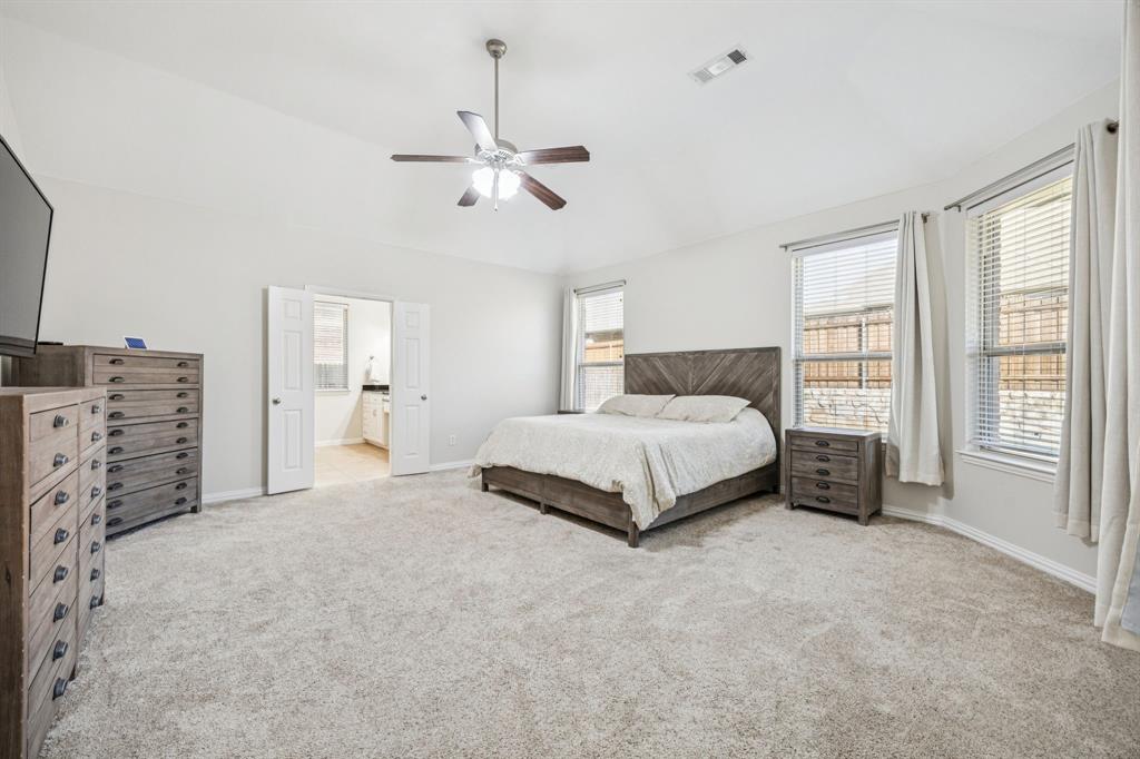 1013 Knoxbridge Road Forney, TX 75126 - Photo 17 of 39 a spacious bedroom with a bed a chandelier and a large window