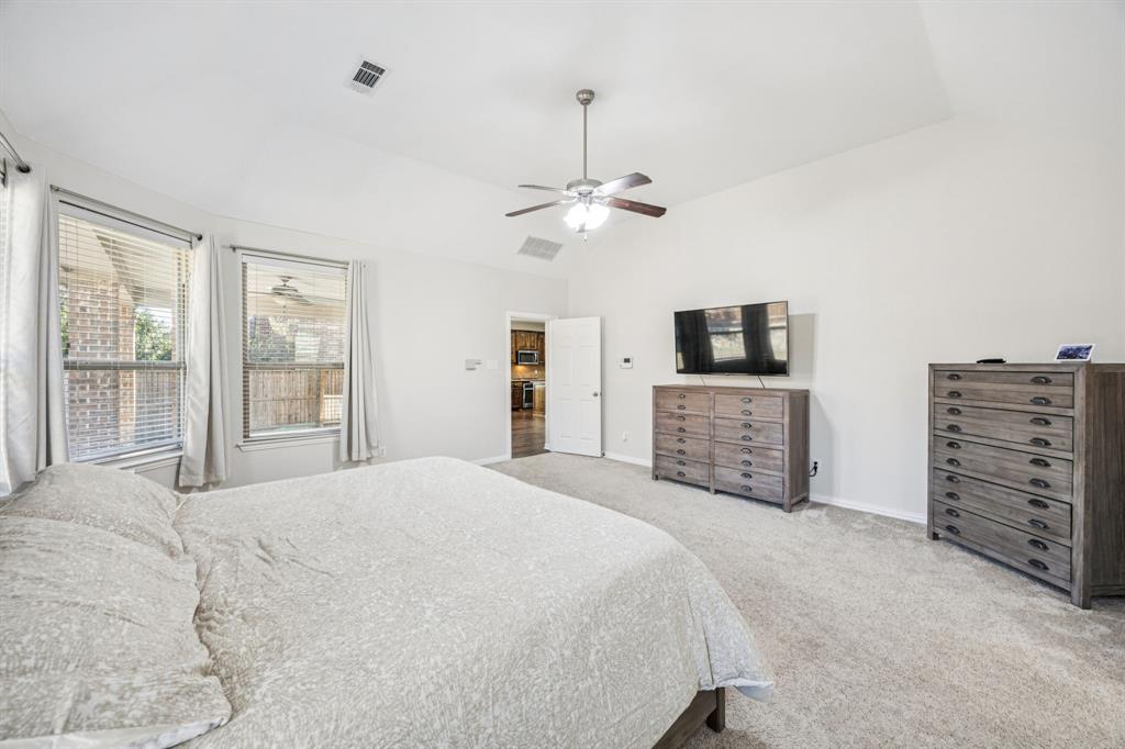 1013 Knoxbridge Road Forney, TX 75126 - Photo 18 of 39 a spacious bedroom with a bed a dresser and a flat tv screen