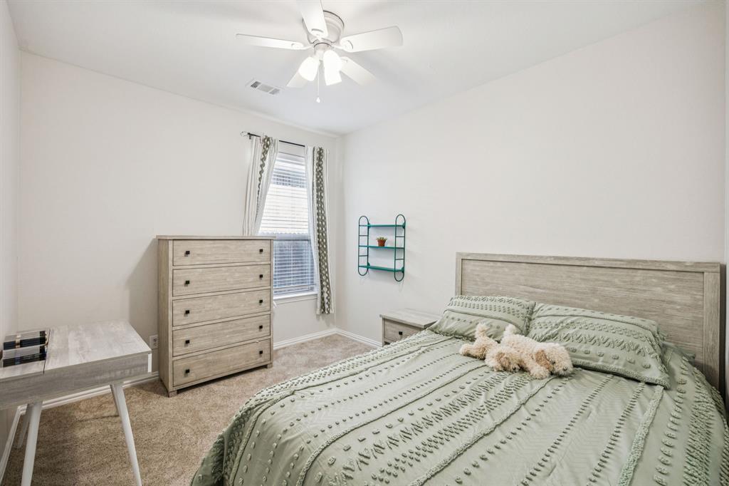 1013 Knoxbridge Road Forney, TX 75126 - Photo 21 of 39 a bedroom with a bed and a chandelier