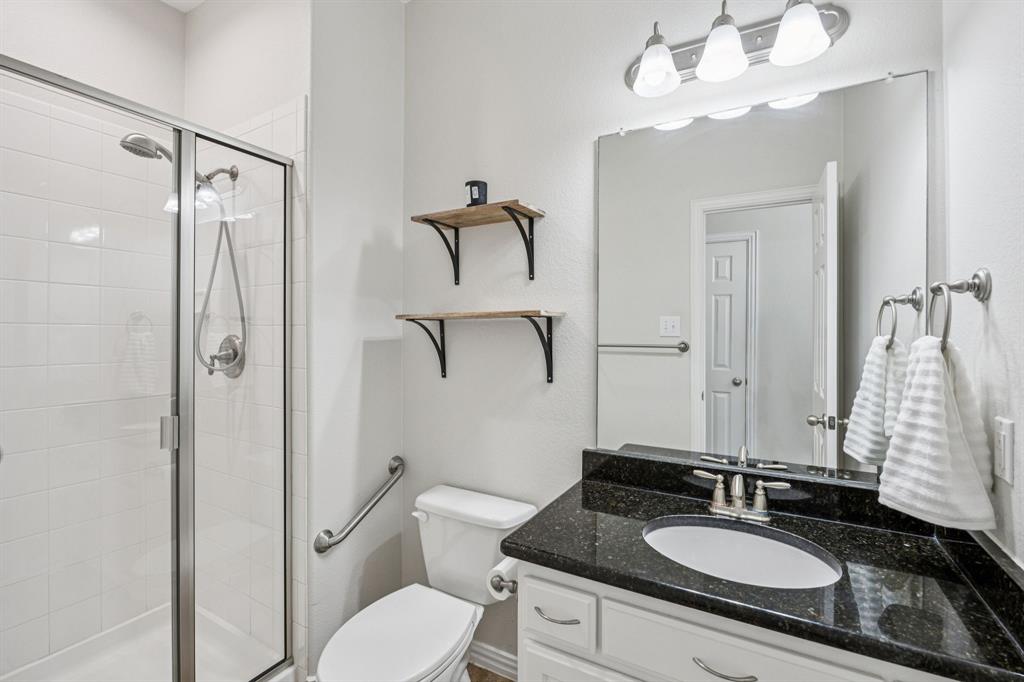 1013 Knoxbridge Road Forney, TX 75126 - Photo 22 of 39 a bathroom with a granite countertop sink toilet a mirror and shower