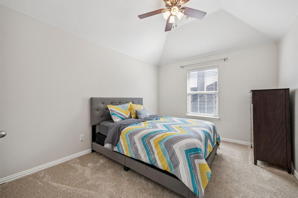 1013 Knoxbridge Road Forney, TX 75126 - Photo 28 of 39 a bedroom with a bed and a chandelier