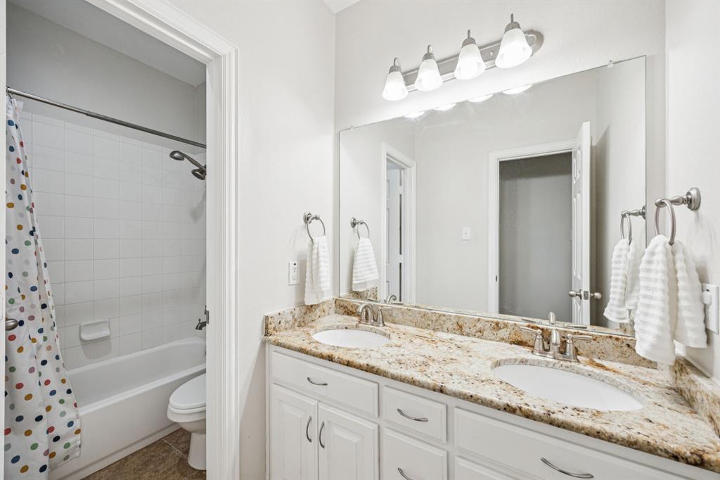 1013 Knoxbridge Road Forney, TX 75126 - Photo 29 of 39 a bathroom with a granite countertop sink mirror toilet and bathtub