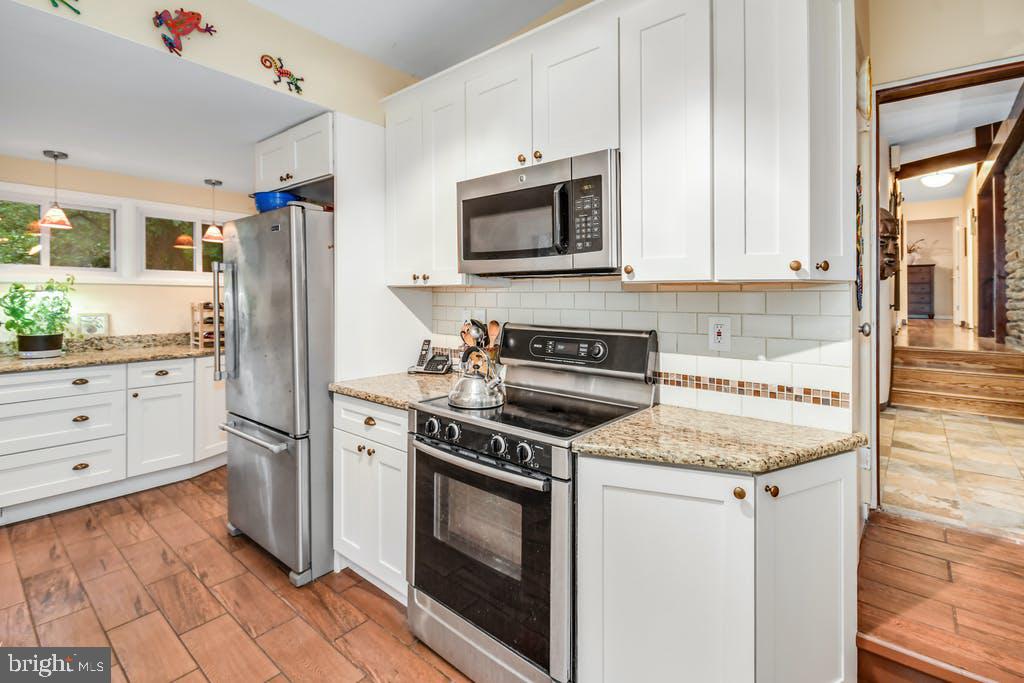 111 Ashmead Road Cheltenham, PA 19012 - Photo 11 of 18 a kitchen with white cabinets and stainless steel appliances