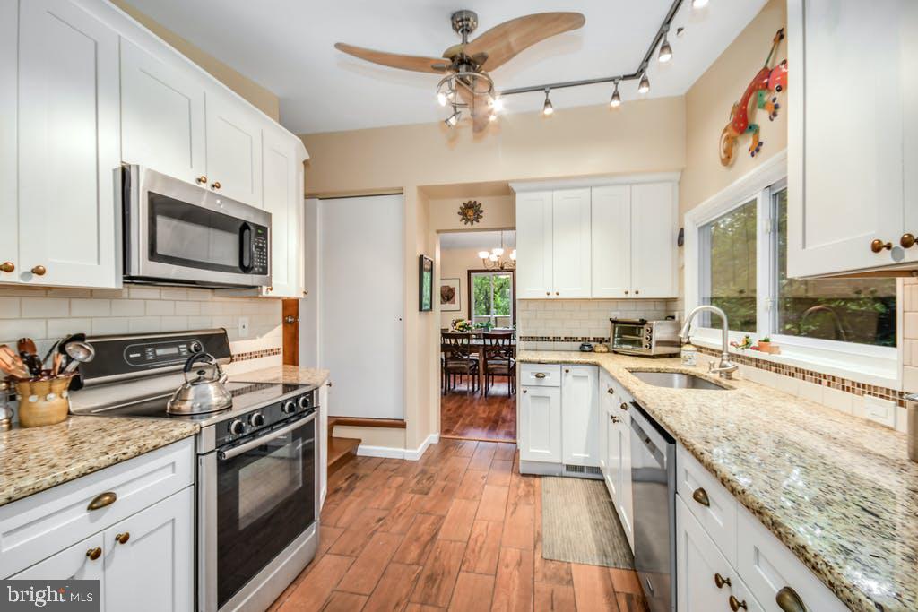 111 Ashmead Road Cheltenham, PA 19012 - Photo 10 of 18 a kitchen with stainless steel appliances granite countertop wooden cabinets stove top oven and sink