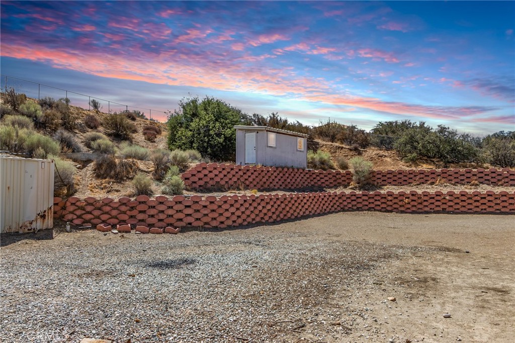 7170 Joshua Road Oak Hills, CA 92344 - Photo 18 of 59 a view of a wooden house with a yard