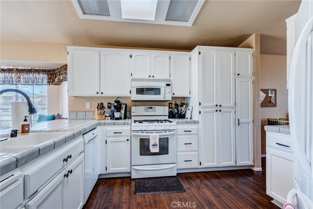 7170 Joshua Road Oak Hills, CA 92344 - Photo 28 of 59 a kitchen with a white cabinets and wooden floor