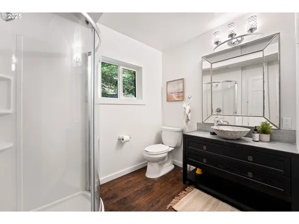 a bathroom with a toilet a sink a mirror and a window