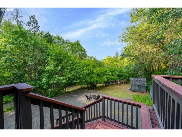 a balcony with wooden floor and yard in the back