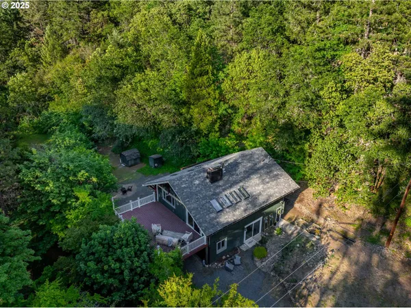 an aerial view of a house with a big yard and large trees