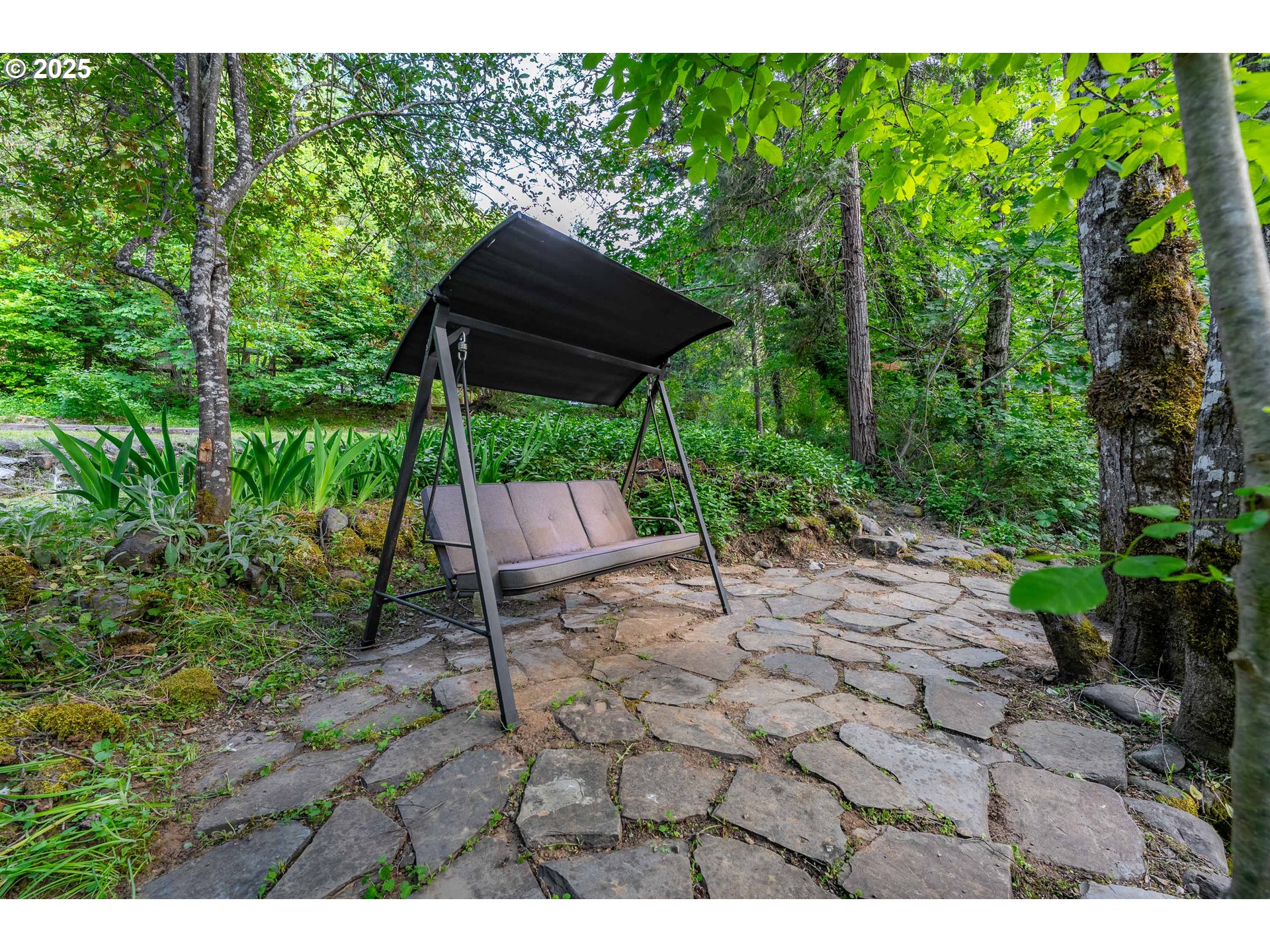 988 Savage Creek Road Grants Pass, OR 97527 - Photo 45 of 48 a backyard of a house with table and chairs under an umbrella