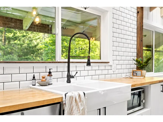 a bathroom with a tub a sink and a large window