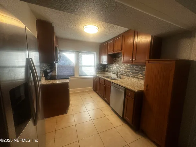 a large kitchen with a large counter top stainless steel appliances and cabinets