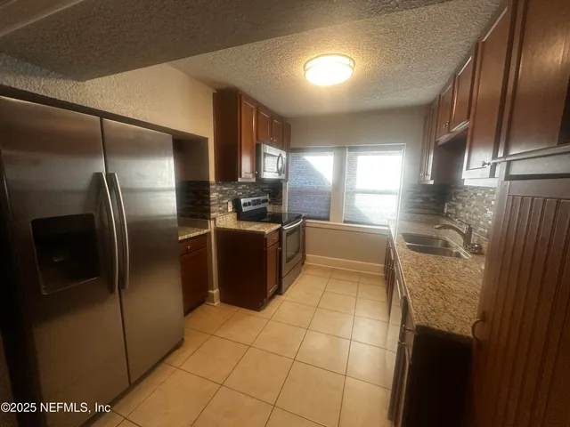 a kitchen with stainless steel appliances granite countertop a refrigerator a oven a sink and dishwasher