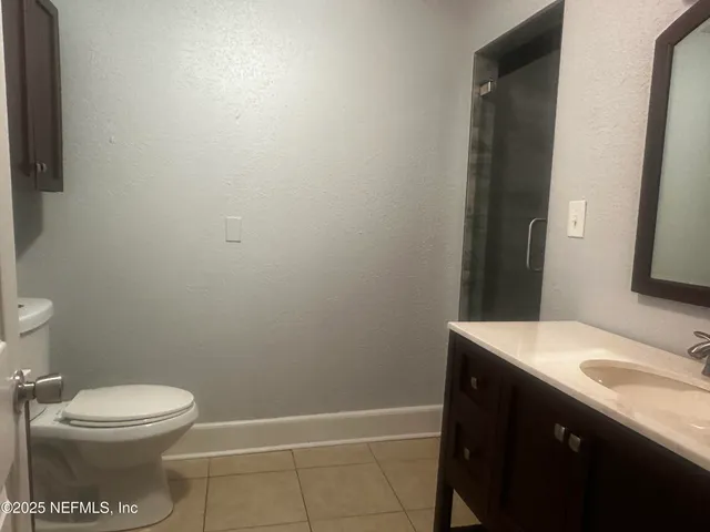 a bathroom with a granite countertop toilet and a sink