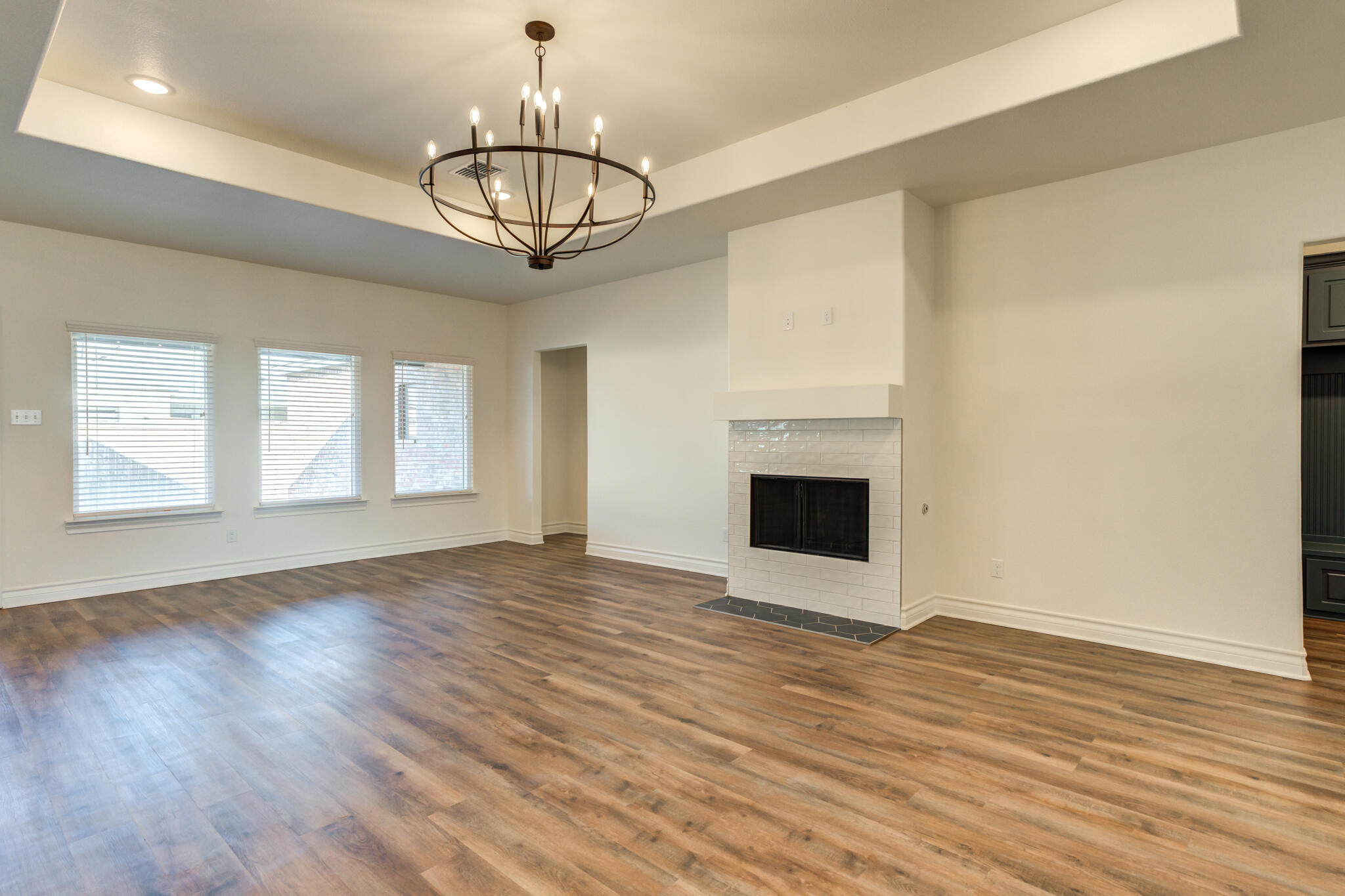 3710 144th Street Lubbock, TX 79423 - Photo 14 of 53 a view of empty room with wooden floor and fireplace