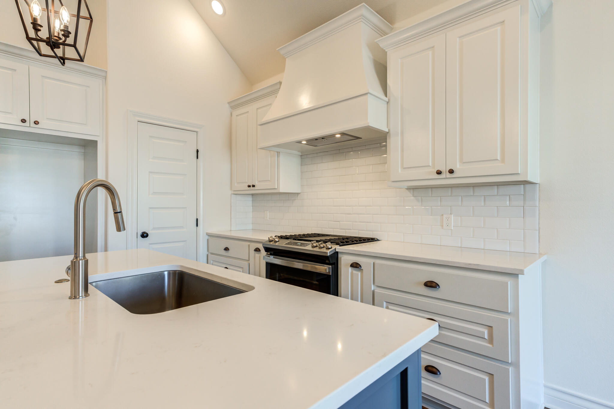 3710 144th Street Lubbock, TX 79423 - Photo 23 of 53 a kitchen with white cabinets and a stove
