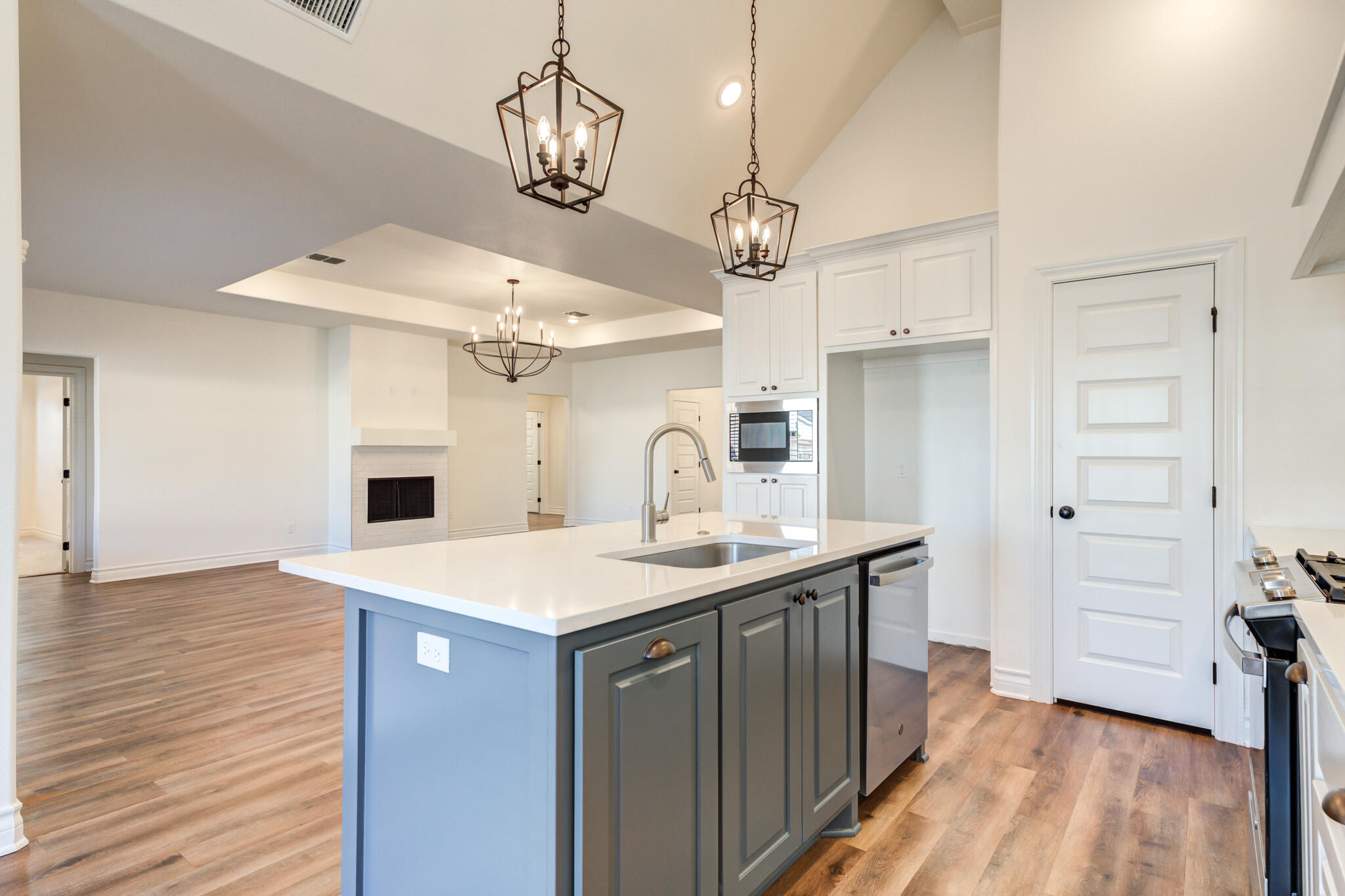 3710 144th Street Lubbock, TX 79423 - Photo 26 of 53 a kitchen with a sink a chandelier stainless steel appliances and wooden floor