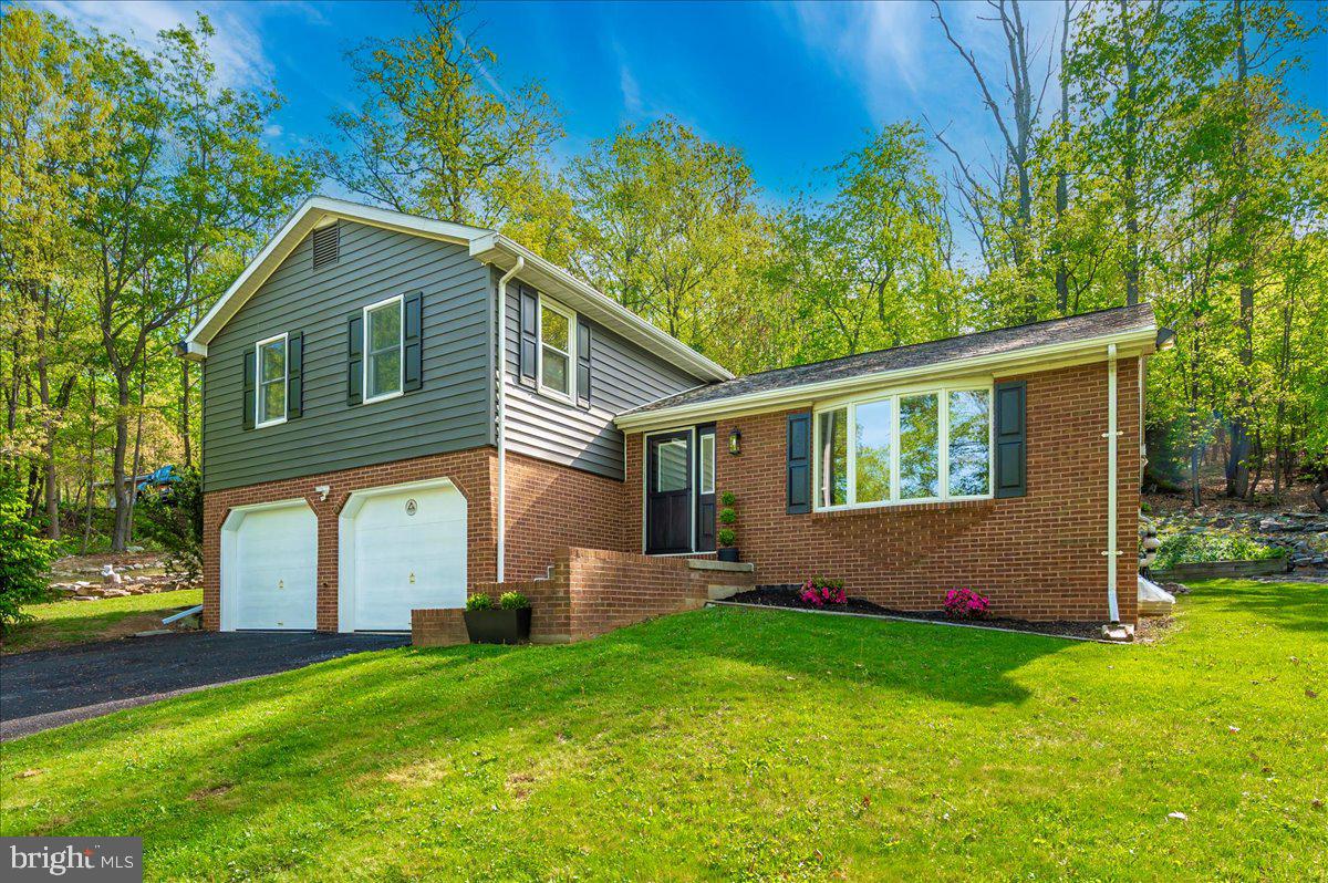 a front view of house with yard and green space