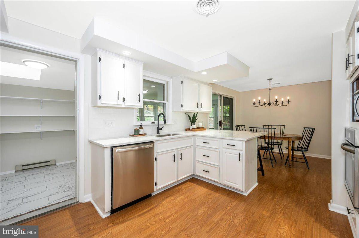 13449 Edgemont Road Smithsburg, MD 21783 - Photo 18 of 70 a kitchen with white cabinets stove and wooden floor