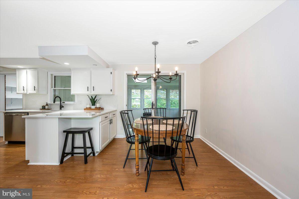 13449 Edgemont Road Smithsburg, MD 21783 - Photo 10 of 70 a dining room with furniture a chandelier and wooden floor