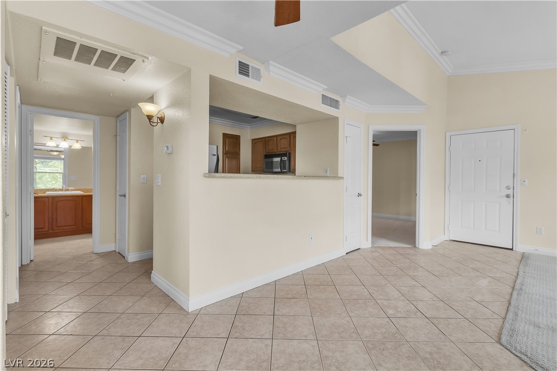 8101 West Flamingo Road, Unit 2001 Las Vegas, NV 89147 - Photo 18 of 28 A well-lit living area features tiled flooring and an open-concept pass-through to the kitchen.