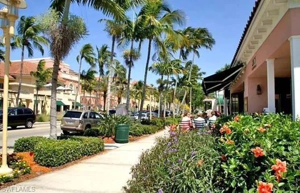 a row of palm trees sitting in front of a house