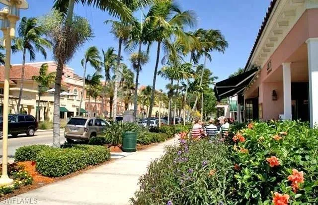 a row of palm trees sitting in front of a house