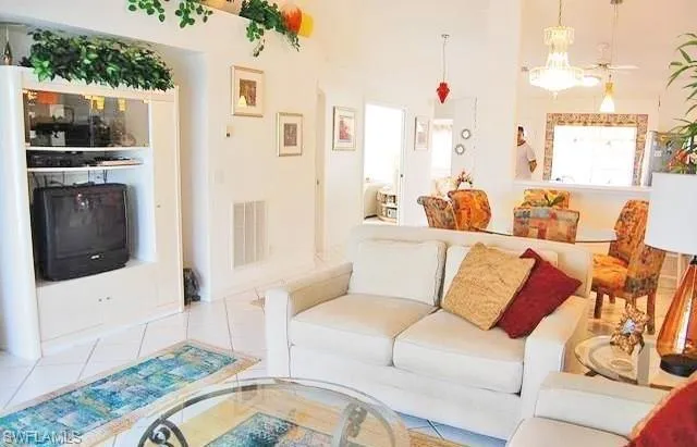 a living room with furniture a flat screen tv and a floor to ceiling window