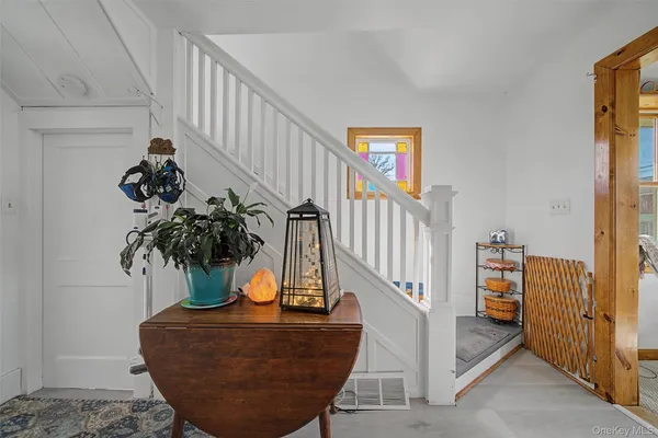 a view of staircase with lots of frames on wall and a potted plant