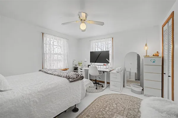 a spacious bedroom with a bed and a flat screen tv