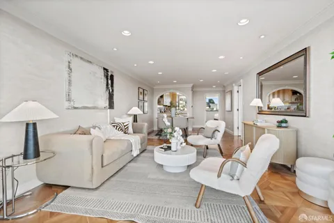 a living room with furniture and a white wall next to a window