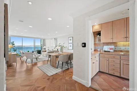 a kitchen with stainless steel appliances kitchen island granite countertop a table chairs sink and cabinets